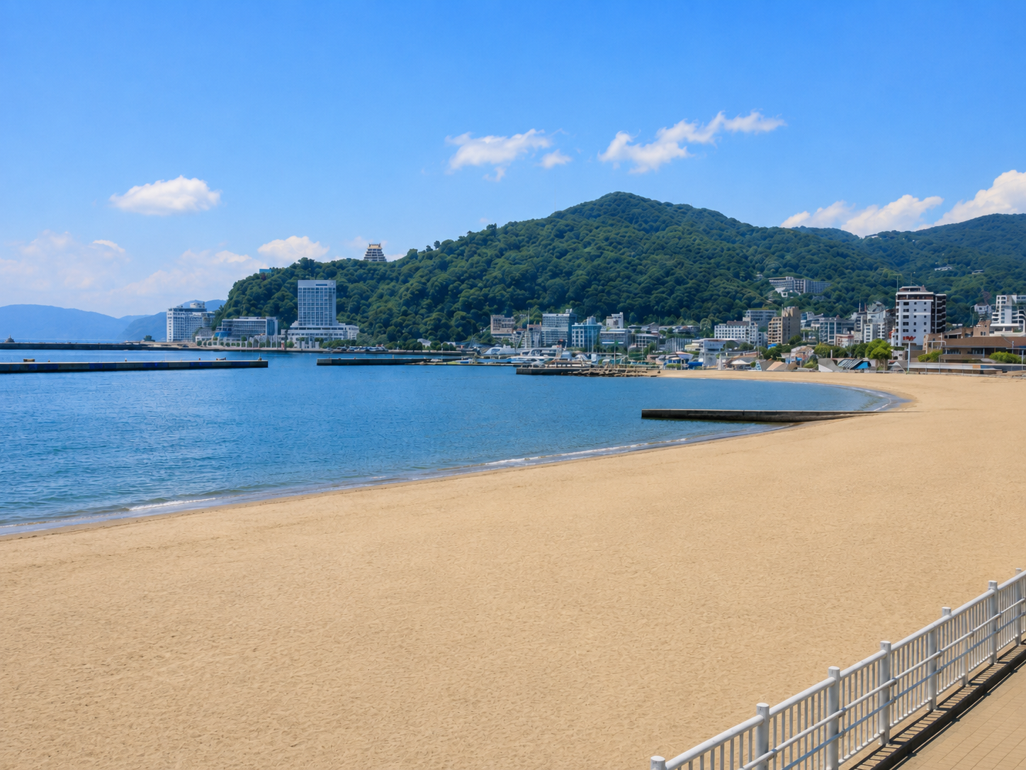 熱海サンビーチの全景。白い砂浜と青い海、熱海の街並み